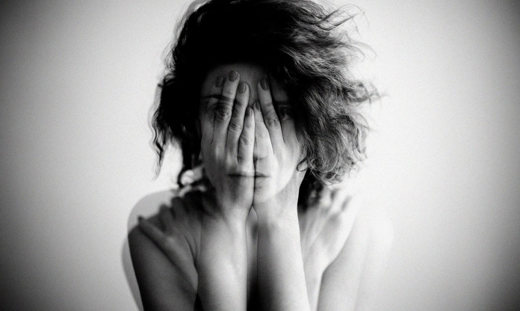 Double exposure black and white portrait of a woman covering her face and eyes with her hands | APEX Performance & Aesthetics in Sandy, UT