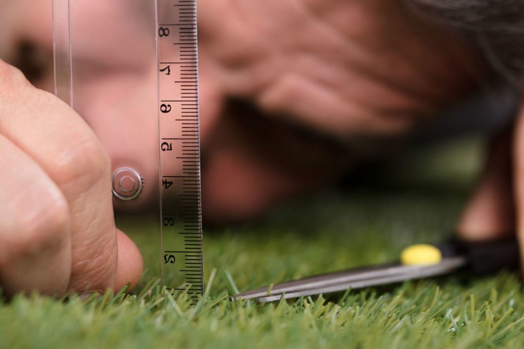 Close-up Of A Man Using Measuring Scale While Cutting Grass With Scissors | APEX Performance & Aesthetics in Sandy, UT
