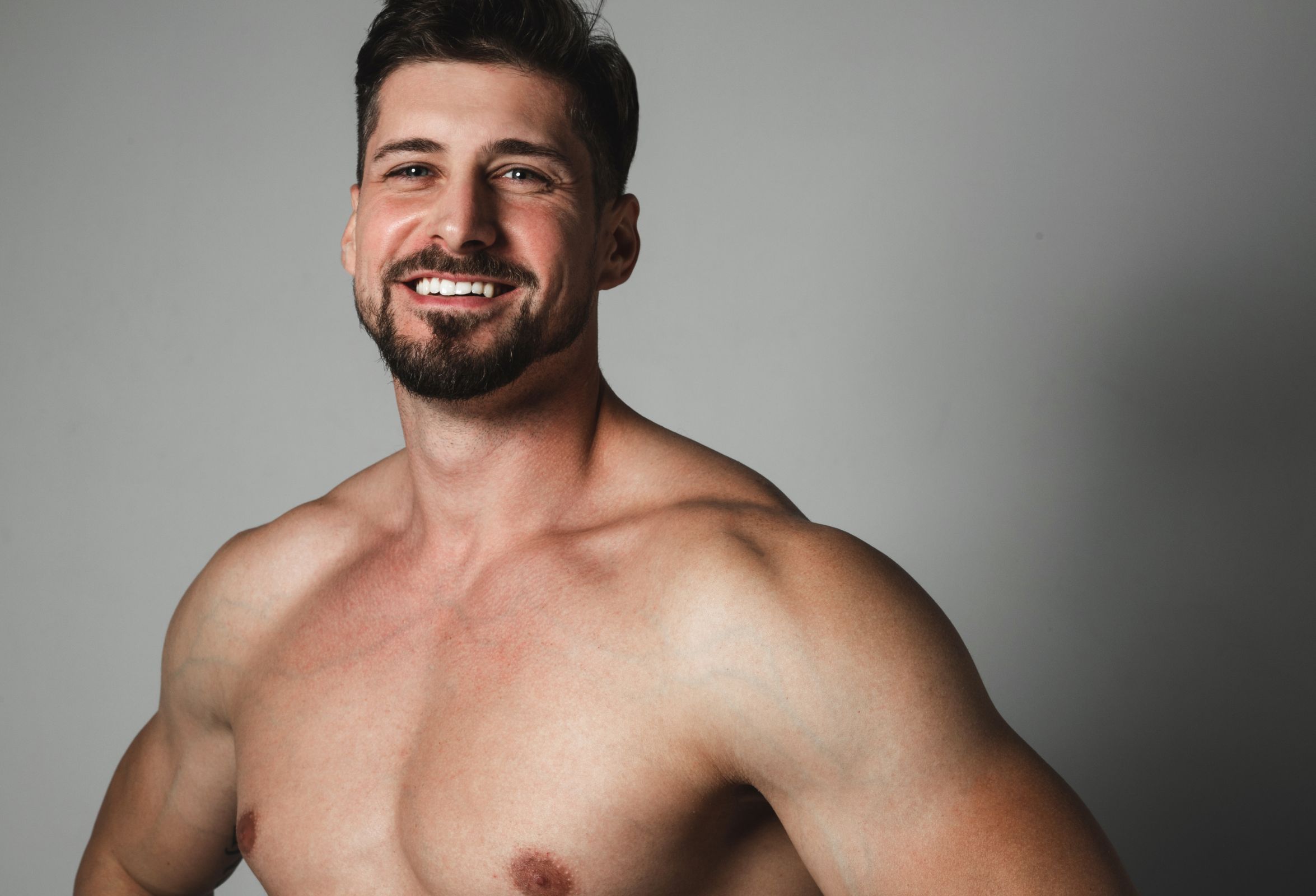 Close up view of happy young brunette man with naked torso smiling | APEX Performance & Aesthetics in Sandy, UT